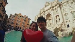 Tourist couple taking a selfie at Trevi fountain with heart Stock Footage