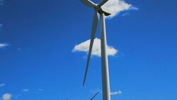 Windmill tilts down to shot of Windfarm. Summer. Stock Footage