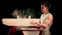 SLO MO Gymnast clapping excess chalk off hands in gym Stock Footage