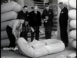 1942: RUBBER BOAT MAKING: Male demonstrating rapid dinghy rubber boat inflation, men in suits & Officer timing inflation w/ watch. 'Zodiac' GARMENT MAKING: Men working w/ sewing machines in garment shop. Males folding high-altitude clothing. WWII Instructional Video
