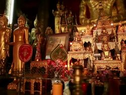 MS PAN Shot of altar with golden statues pictures and flowers / Luang Prabang, Laos Stock Footage