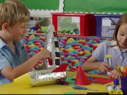 MS Young girl and boy sitting at classroom table working on rocket art project / Great Yarmouth, England, United Kingdom Stock Footage