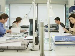 LA WS two men and two women working on  desk in modern office, one woman handing folder across table to man Stock Footage