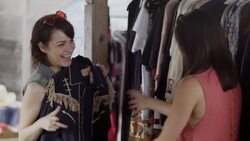 Young woman shopping with friend holds up Western shirt with tassels and laughs Stock Footage