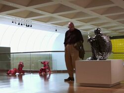 WS Man walking around metal sculpture in exhibit case on pedestal in modern art museum / Palm Springs, California, USA Stock Footage