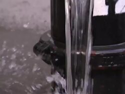 Water flows from a fire hydrant as pedestrians walk by. Stock Footage