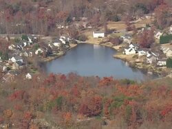 MS AERIAL TD Shot of houses surrounded by autumn color trees with small lake / South Carolina, United States Stock Footage