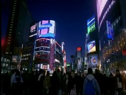 MS people walking beneath billboards at night in Shibuya, Tokyo, Japan Stock Footage