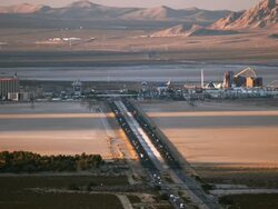 WS HA of late afternoon sun throwing long shadows across Ivanpah Valley and Interstate 15 at California Nevada state line in Mojave desert with casinos and roller coasters in far distance / Primm, Nevada, USA Stock Footage