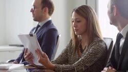 MS Smiling female business executive reviewing paperwork during meeting with colleagues in office conference room Stock Footage
