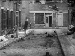 B/W 1917 policeman Charlie Chaplin patrolling in city street + scaring curious mob away Stock Footage