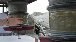 Close up of a hand moving the Buddhist prayer wheels at a Buddhist monastery in Ladakh Stock Footage