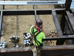 Overhead view of a steelworker at 12-story commercial construction site Stock Footage
