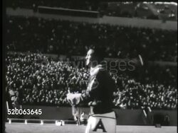 1963: UNITED STATES AIR FORCE ACADEMY: VS Male falconer flying 'Mach 1' falcon during show (half time) on field in Falcon Stadium, falcon diving for prey thrown into air, crowd clapping, Generals clapping. Falcon Football, raptor, bird, falconry Instructional Video