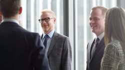 MS Smiling business executive in discussion with colleagues during informal meeting in office Stock Footage