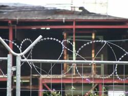 Barbed wire on fence, abandoned factory background, HD Stock Footage
