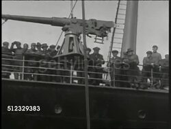 1917: EXECUTIVE ORDER TO ARM SHIPS: Artillery, Naval gun being craned up next to Merchant ship, men along railing cheering. Naval officer walking on deck past large ship's gun. WS Bow of ship w/ large artillery gun on deck. 'Armed Neutrality' Instructional Video