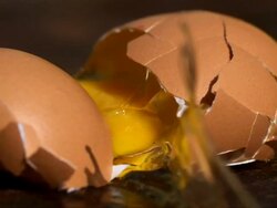 Egg smashing onto wooden surface - 5000fps (200x slowed down) Stock Footage