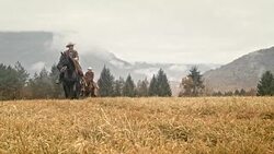 Cowgirl riding across mountain with two cowboys Stock Footage