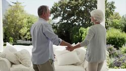 Senior couple hugging on patio Stock Footage