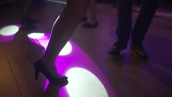 Close up of dancing women and men's feet on the dance floor at the night club or discotheque. Crowd women with beautiful legs in high heels dancing. Stock Footage