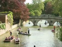 MS Shot of Punters on River Cam by bridge behind Kings College Cambridge / Cambridge, Cambridgeshire, United Kingdom Stock Footage