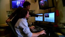 MS PAN Female producer advising editor and pointing at computer monitor in studio/ New York, New York Stock Footage