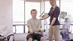 Physical therapist working with teenage boy Stock Footage