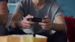 Guys sitting on couch playing video games Stock Footage