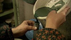 An artist pours green glaze into a small container. Stock Footage