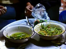 MS SLO MO Shot of two bowls with food and several hands serving with spoons / Luang Prabang, Laos Stock Footage
