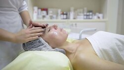 Beautician applying cream of woman Stock Footage
