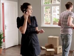 WS Woman talking on phone while boyfriend falls of ladder in background / Berlin, Germany Stock Footage