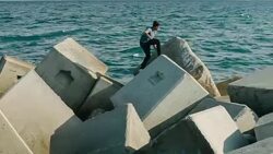 Practicing parkour in the sea wall Stock Footage