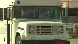 A blue military SUV swerves to stop a white bus driven by an Arab dissident. Stock Footage
