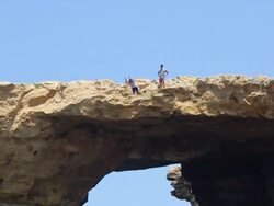 A young man jumping off the Azure Window arch bridge cliff on the island of Gozo in the Republic of Malta. - Model Released - HD Stock Footage