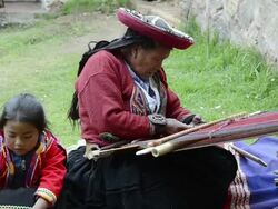 MS Sitting woman with child in traditional dress weaving yarn / Cuzco or Cusco, Peru Stock Footage