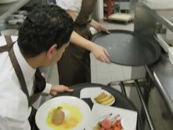 POV waiters taking prepared plates from the plating area in a restaurant kitchen to carry them to the dining room; camera follows waiter Stock Footage