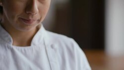 Female pastry chef holds tray of confections and looks up at camera Stock Footage