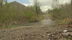 Pickup truck driving through stream News Clip