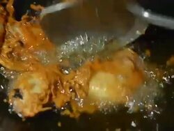 three fried chicken wing is cooking until well done in black pan Stock Footage