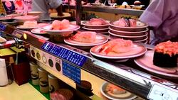 Sushi plates on rails in Japanese restaurant Stock Footage