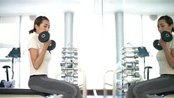 Women is exercising with dumbbells in gym Stock Footage