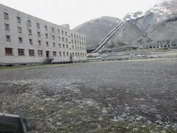 An abandoned building with seagulls nesting on the windows and an old mine in the background, Pyramiden, a Soviet Ghost Town on the archipelago of Svalbard Stock Footage
