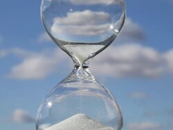 Sand runs through glass hourglass Stock Footage