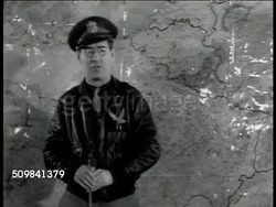1942 REPRISAL: MISSION BRIEFING: US Officer standing at map using pointer, SOT explaining secondary target, '...and, you'll love this, it's the country club of the German Air Force' MS Crew members laughing. DOLLY Past seated, listening crew members. Instructional Video