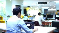 Business people using laptop and reviewing blueprints at desk Stock Footage