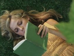 woman reading a book on the grass Stock Footage