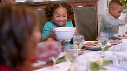 Cute young girl rubs hands together and gazes hungrily at the mashed potatoes (dolly-shot) Stock Footage