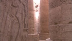 Bright sunlight shines between huge, carved pillars in the Karnak Temple in Egypt. Stock Footage